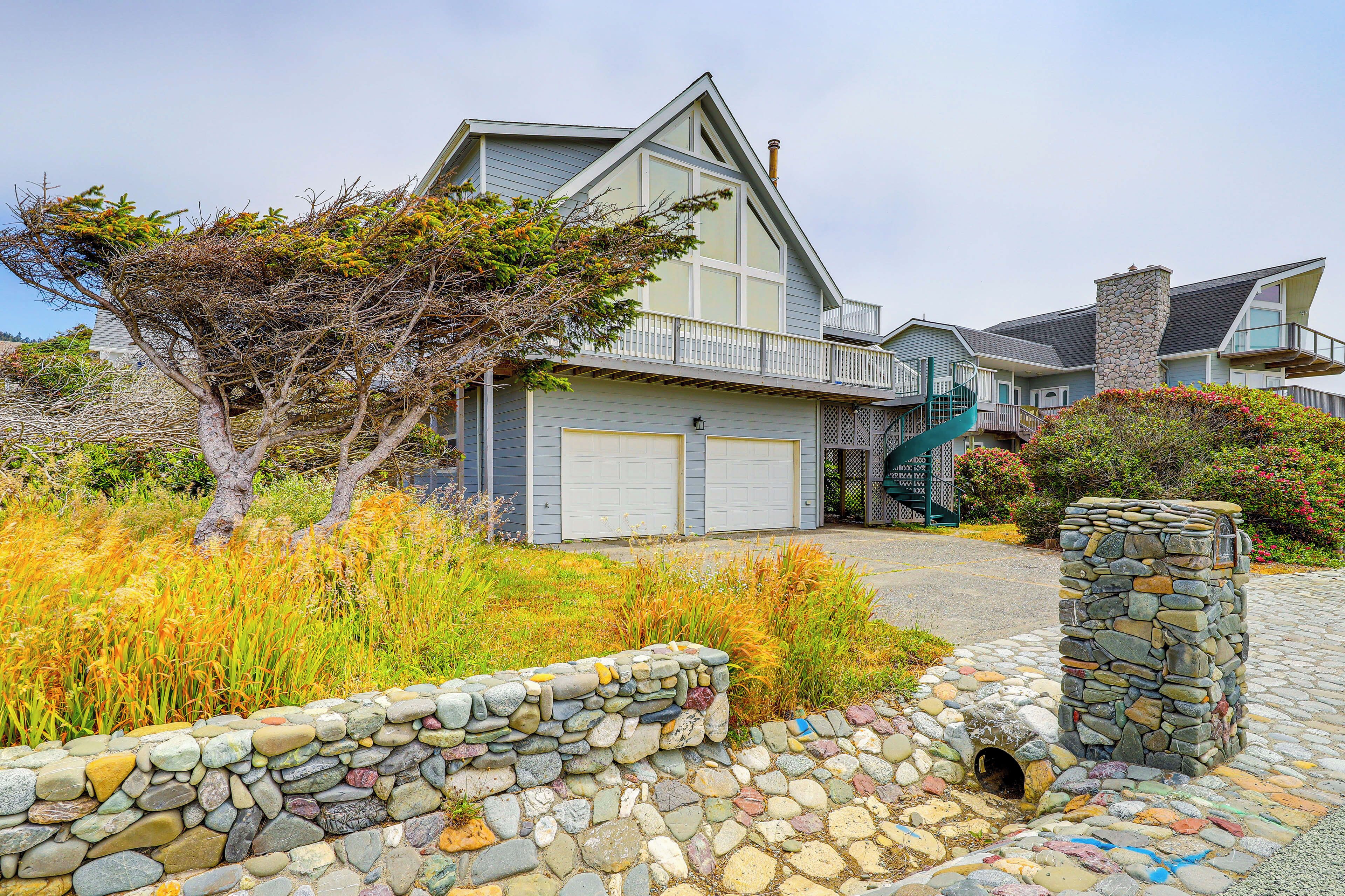 A modern two-story house with a stone pathway leading to the garage.