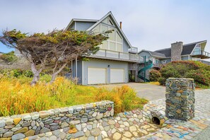 A modern two-story house with a stone pathway leading to the garage. - Deck + Walk to Beach: Southern Oregon Coast Home! (Gold Beach)