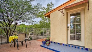 A patio with a table and chairs, potted plants, and a door with a window.