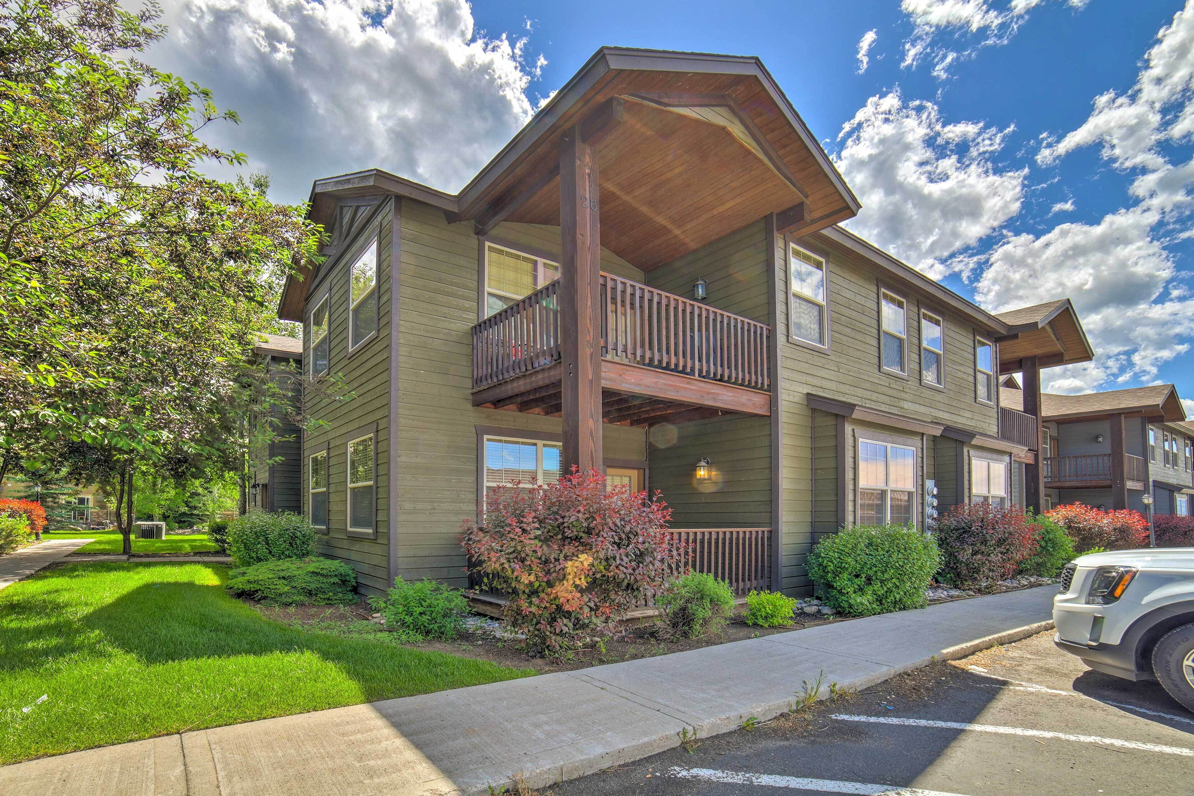 A two-story building with a balcony on the second floor, a covered porch, and a well-maintained lawn.