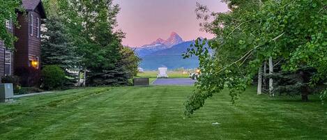 A grassy lawn with a view of mountains in the background.