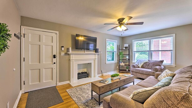 A living room with a fireplace, a ceiling fan, a television, and a couch. - Charming Charleston Home w/ Yard & Fire Pit! (Charleston)
