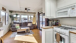 A modern kitchen with a stove, microwave, and cabinets.