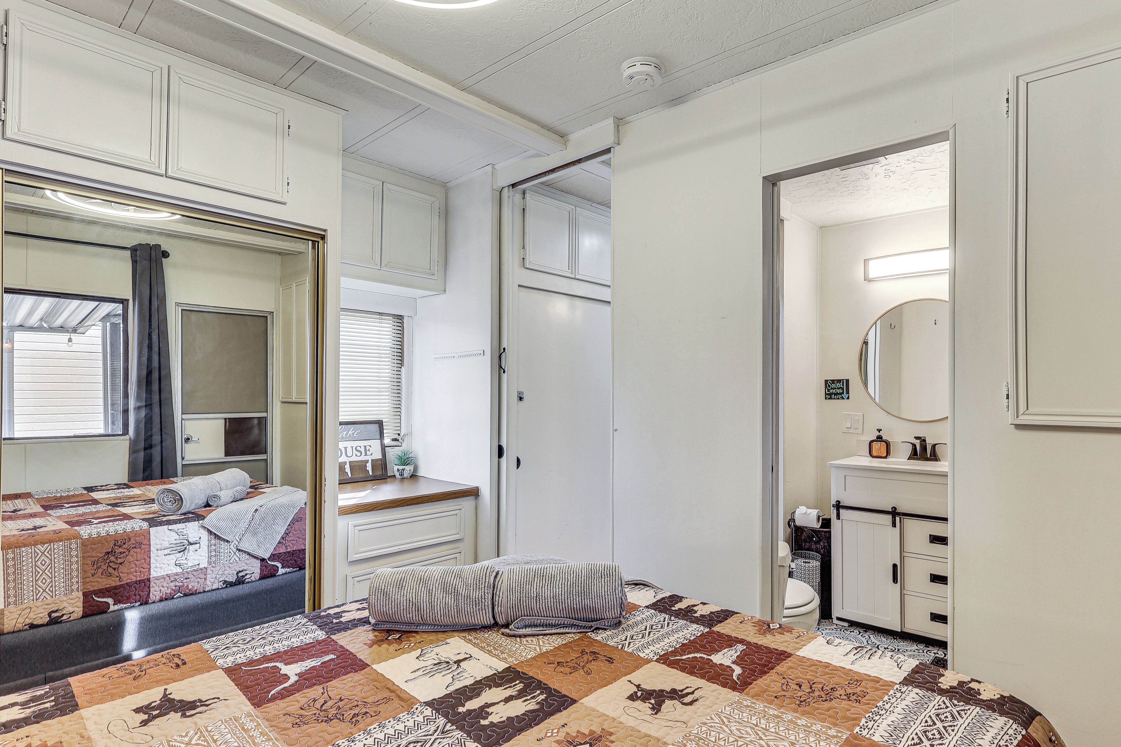Ein Schlafzimmer mit Bett, Nachttisch, Spiegel und Kleiderschrank.