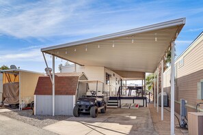 A covered outdoor area with a golf cart, a covered bench, and a small building. - Dock & Beach Access: Cozy Lake Havasu City Home! (Lake Havasu City)