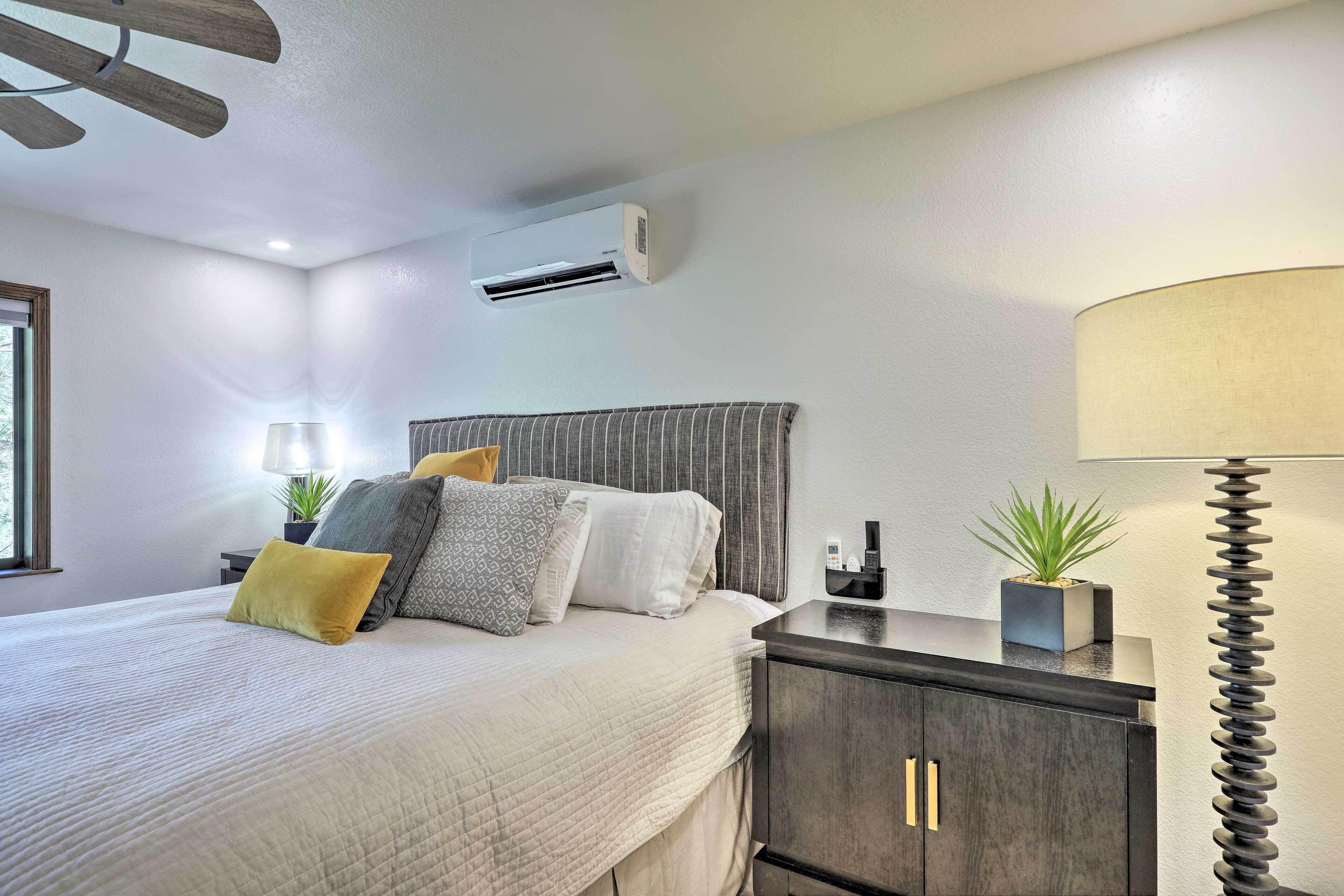 Une chambre à coucher bien rangée, avec un lit, des tables de chevet, une lampe et une plante en pot.