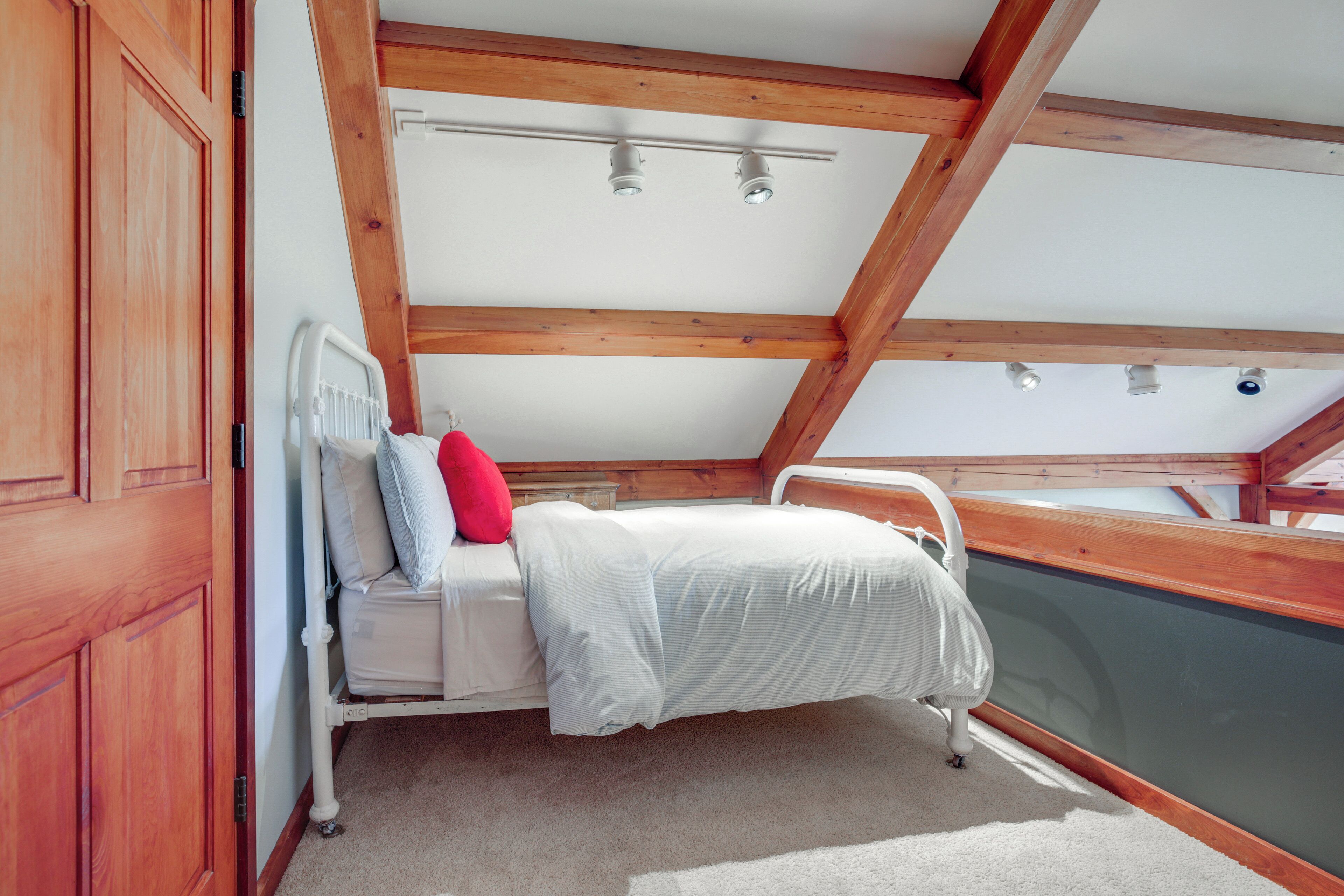 A bedroom with a bed, a window, and a view of the outside.