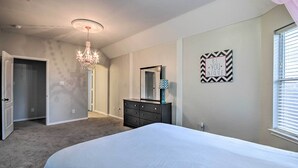 Un dormitorio con cama, cómoda, candelabro y una cita motivadora en la pared.