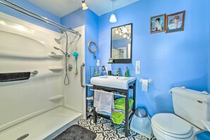 Een badkamer met een bad, wastafel, toilet en douche.