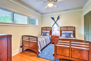 A bedroom with two wooden beds, a ceiling fan, and a window with blinds. - Lakefront Condo w/ Community Pool & Boat Dock (Talladega)
