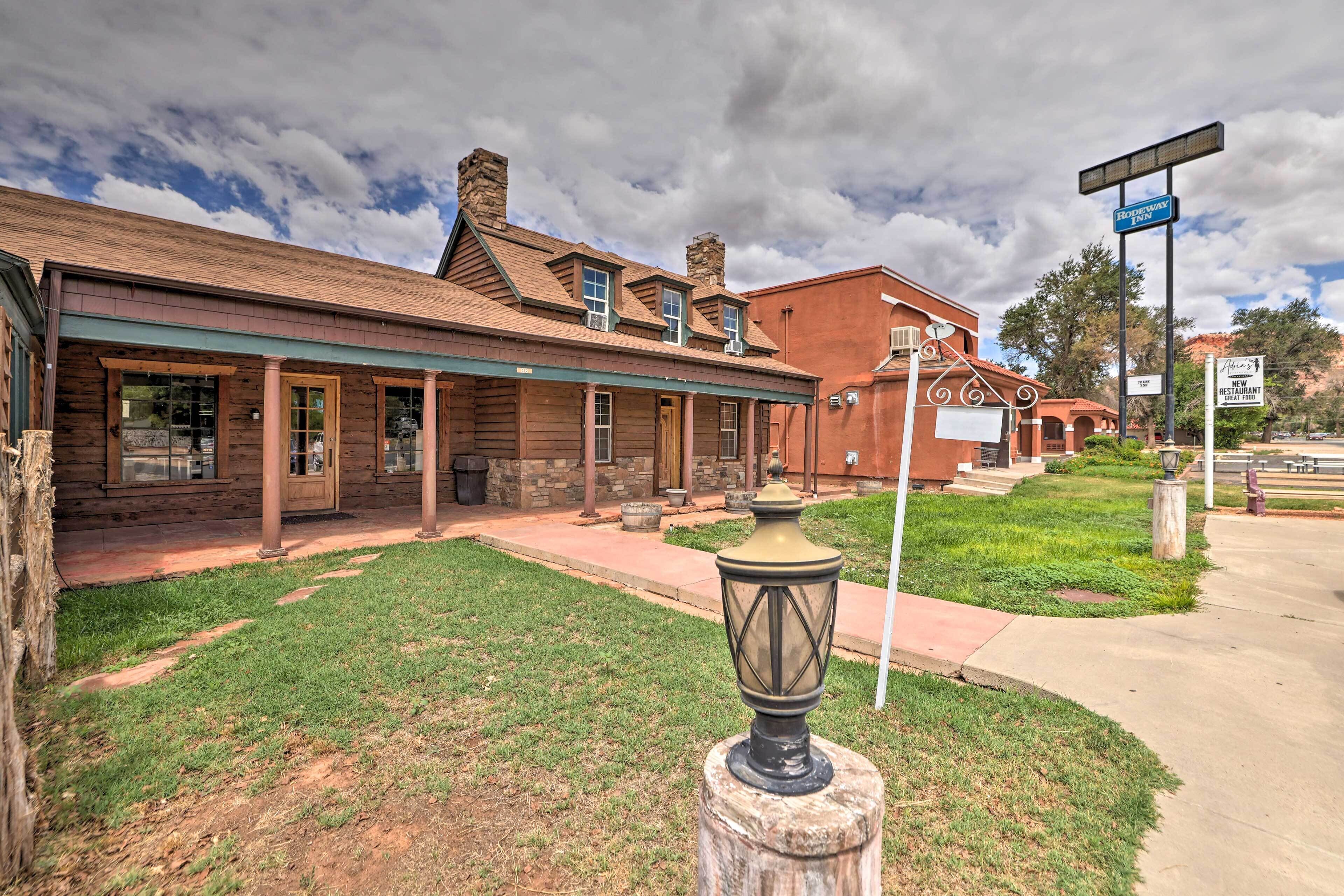 A rustic building with a covered porch and a stone post with a lantern.