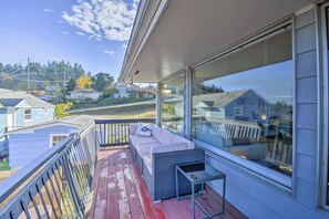 Un balcone con una divano e un tavolino, vista su una zona residenziale.