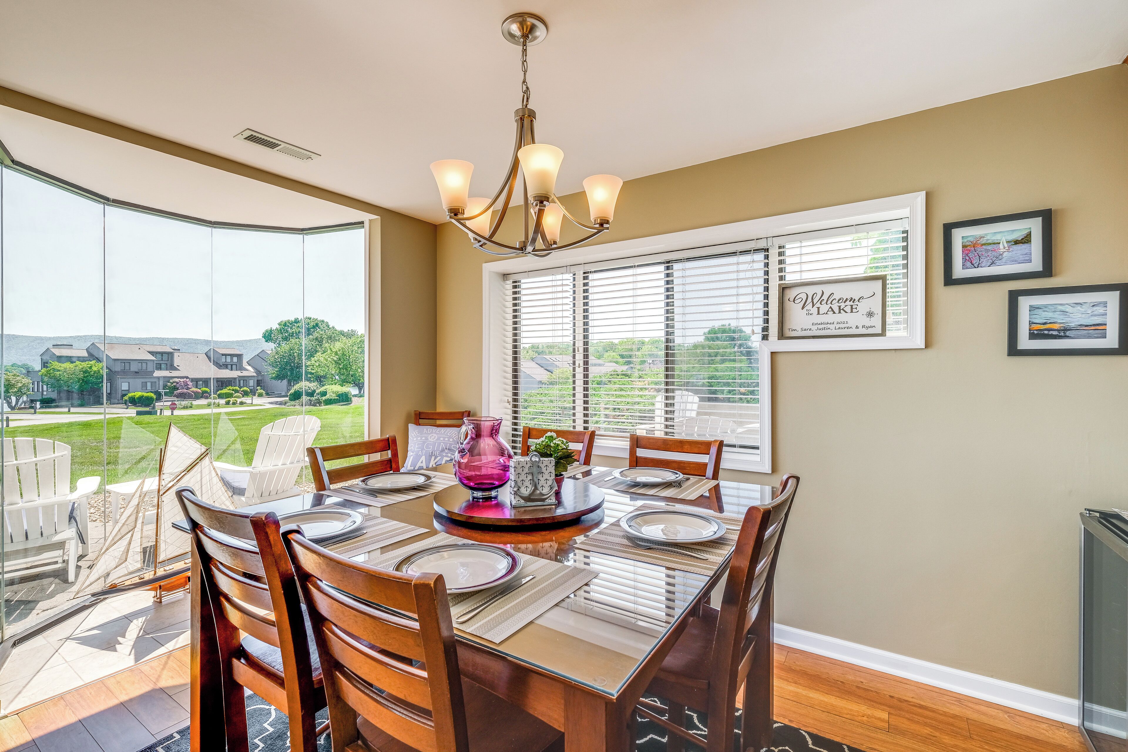 A dining area with a large table, chairs, and a chandelier.