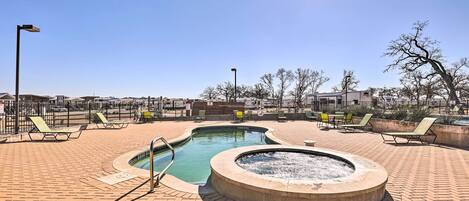 A pool area with lounge chairs and a fire feature.