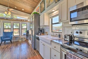 A modern kitchen with a large island, built-in appliances, and large windows. - Upscale Tiny Home - Boho-chic Austin Getaway! (Austin)