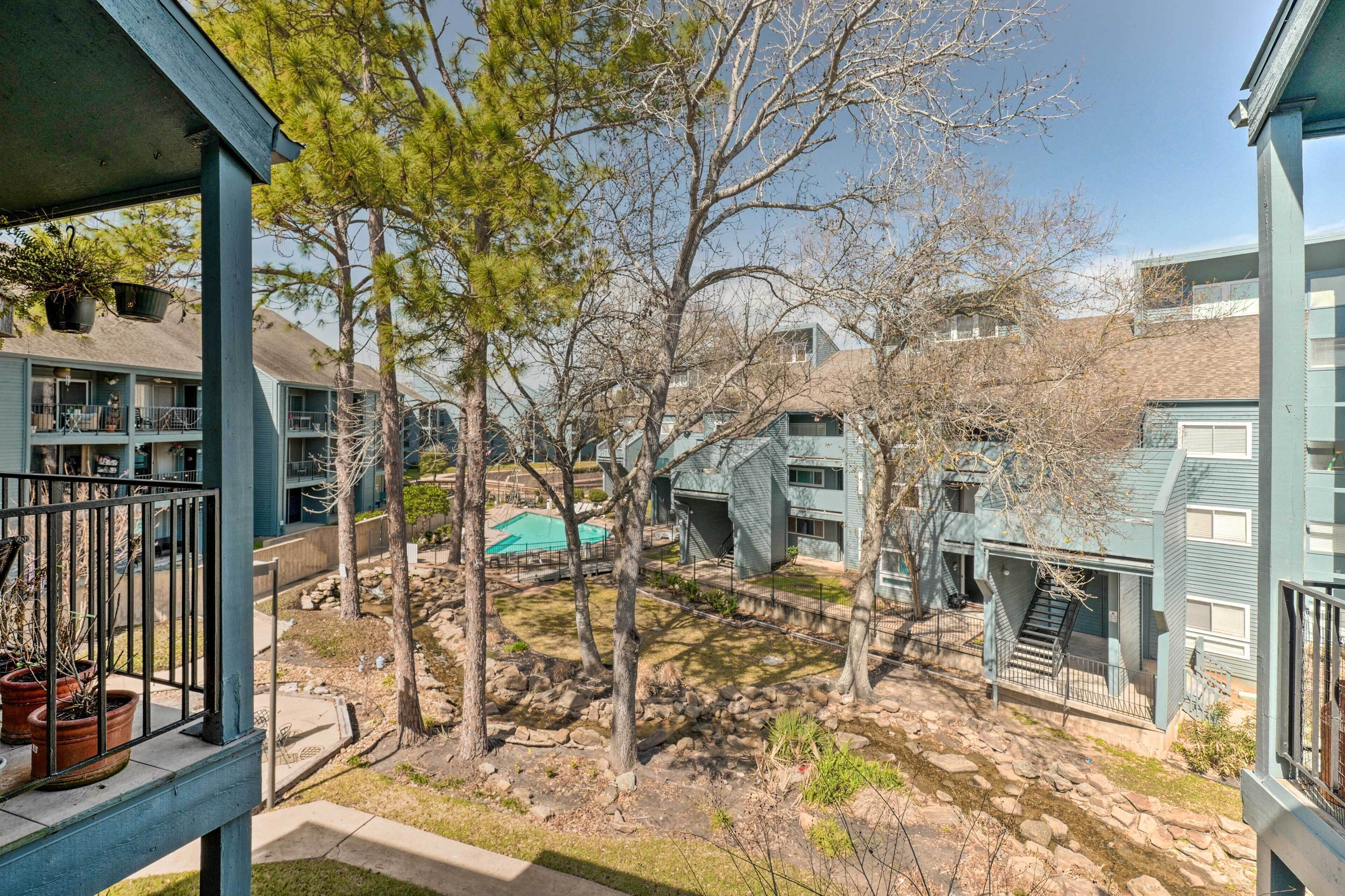A residential area with multiple two-story buildings, a small courtyard with trees, and a visible staircase leading to an upper level.