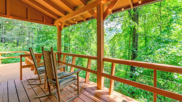 Una terraza de madera con vistas a un bosque.