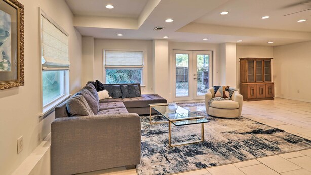 A spacious living room with a sectional sofa, a glass coffee table, and a cabinet. - St Petersburg Hideaway w/ Fire Pit & Grill! (St. Petersburg)