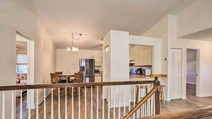 A spacious living area with a wooden staircase, a dining area, and a kitchen with modern appliances. - St Petersburg Hideaway w/ Fire Pit & Grill! (St. Petersburg)