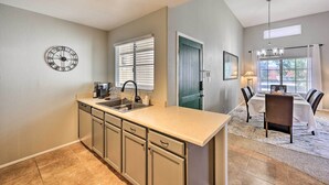 A kitchen with a built-in sink, cabinets, and a clock on the wall. - Modern Scottsdale Condo ~ 10 Mi to Old Town! (Scottsdale)