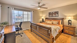 A bedroom with a wooden bed, a desk, a chair, a ceiling fan, and a window with curtains. - Modern Scottsdale Condo ~ 10 Mi to Old Town! (Scottsdale)