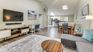 A modern living room with a flat-screen TV, a wooden coffee table, and a gray sofa. - Resort Condo ~ 2 Mi to Sunset Beach Seashore! (Sunset Beach)