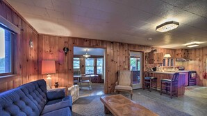A cozy cabin interior with a living room, dining area, and kitchen. - Riverfront Escape w/ Dock: 19 Mi to Saratoga! (Lake Luzerne)
