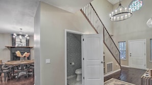 A spacious living area with a wooden dining table, dark wood flooring, a staircase with a railing, and a chandelier. - 2 Mi to Lake: Marvelous Pinetop Home w/ Fireplaces (Pinetop)