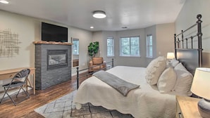 A bedroom with a large bed, a fireplace, a desk, and a chair. - 2 Mi to Lake: Marvelous Pinetop Home w/ Fireplaces (Pinetop)