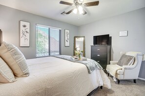 A bedroom with a bed, a chair, a dresser, a television, and artwork on the walls. - 1/2 Mi to Lake: Family Home w/ Hot Tub in Goodyear (Goodyear)