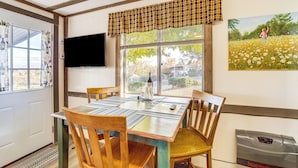 A dining area with a table set for four, wooden chairs, a television mounted on the wall, and a window with a view of the outdoors. - 6 Mi to Old Town, Panoramic Views: Cottonwood Gem! (Cottonwood)