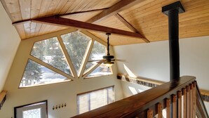 Eine Holzbalkendecke mit geneigtem Design, ein Deckenventilator und ein großes Oberlicht.
