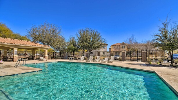 A clear swimming pool with lounge chairs and a covered seating area. - 2-story Surprise Getaway w/ Patio + Fire Pit! (Surprise)