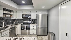 A modern kitchen with white cabinets, stainless steel appliances, and black and white marble countertops. - Heated Pool: Home ~ 5 Mi to Lake Havasu! (Lake Havasu City)