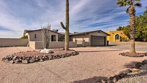 A desert-style house with a prominent cactus in the front yard, a palm tree, and a clear sky. - Heated Pool: Home ~ 5 Mi to Lake Havasu! (Lake Havasu City)