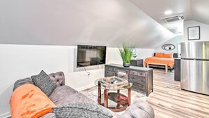 A modern loft apartment with a living area featuring a sofa, coffee table, and a TV. - Fayetteville Apartment w/ Yard: Pets Welcome! (Fayetteville)