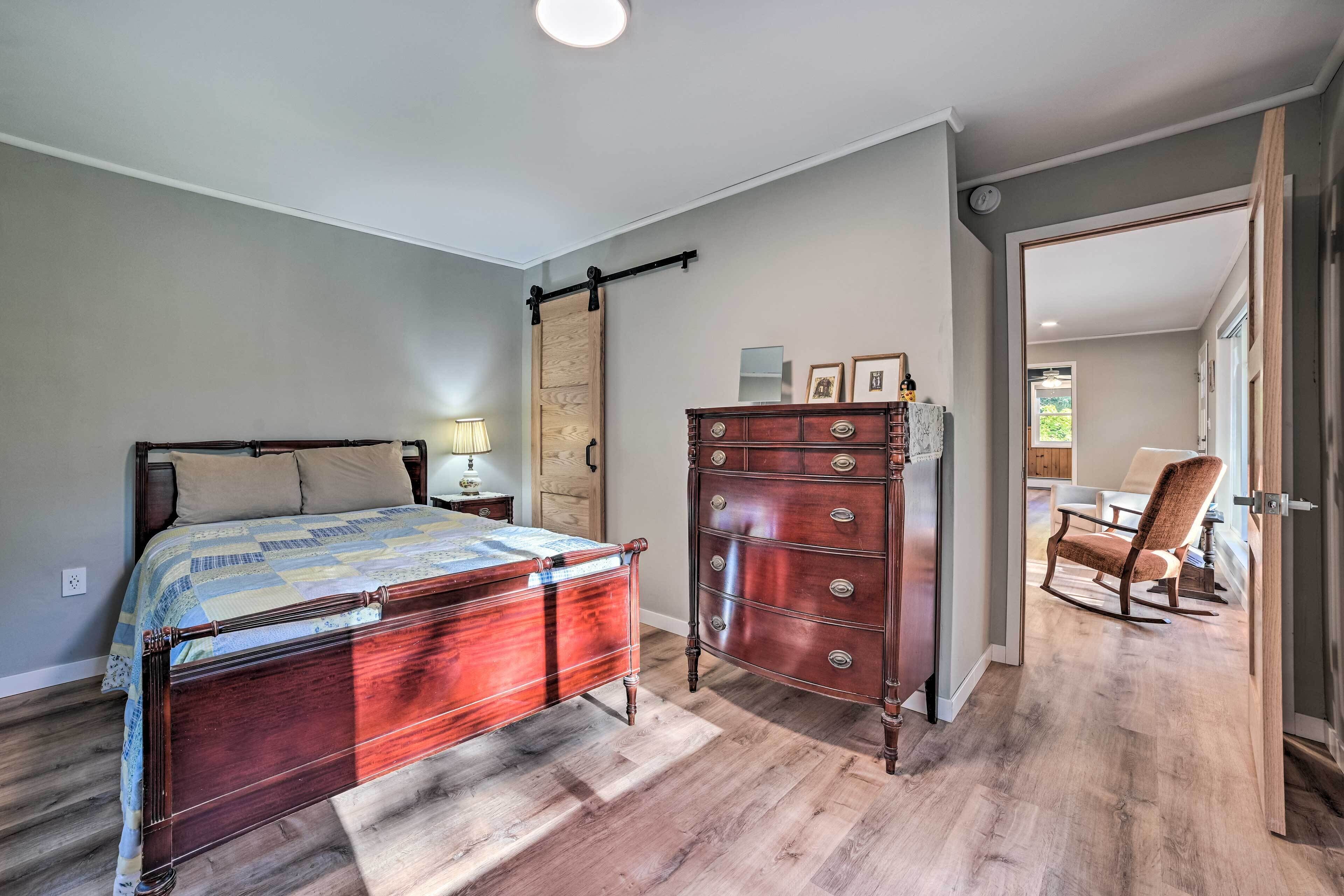 A bedroom with a wooden bed, a dresser, and a chair.