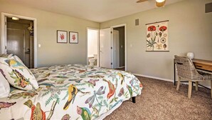 A bedroom with a bed, a desk, and a chair. There is a ceiling fan and a wall-mounted light fixture. - Chic Coos Bay Home w/ Pacific Ocean Views! (Coos Bay)