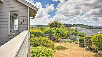 A residential property with a well-maintained garden, a wooden fence, and a clear view of the surrounding landscape.
