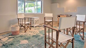 A room with a large window, a foosball table, and several foldable chairs. - Chic Coos Bay Home w/ Pacific Ocean Views! (Coos Bay)