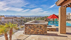 A rooftop pool area with a stone wall, a red umbrella, and a view of mountains. - Luxe Retreat w/ Lake Havasu View & Pool! (Lake Havasu City)