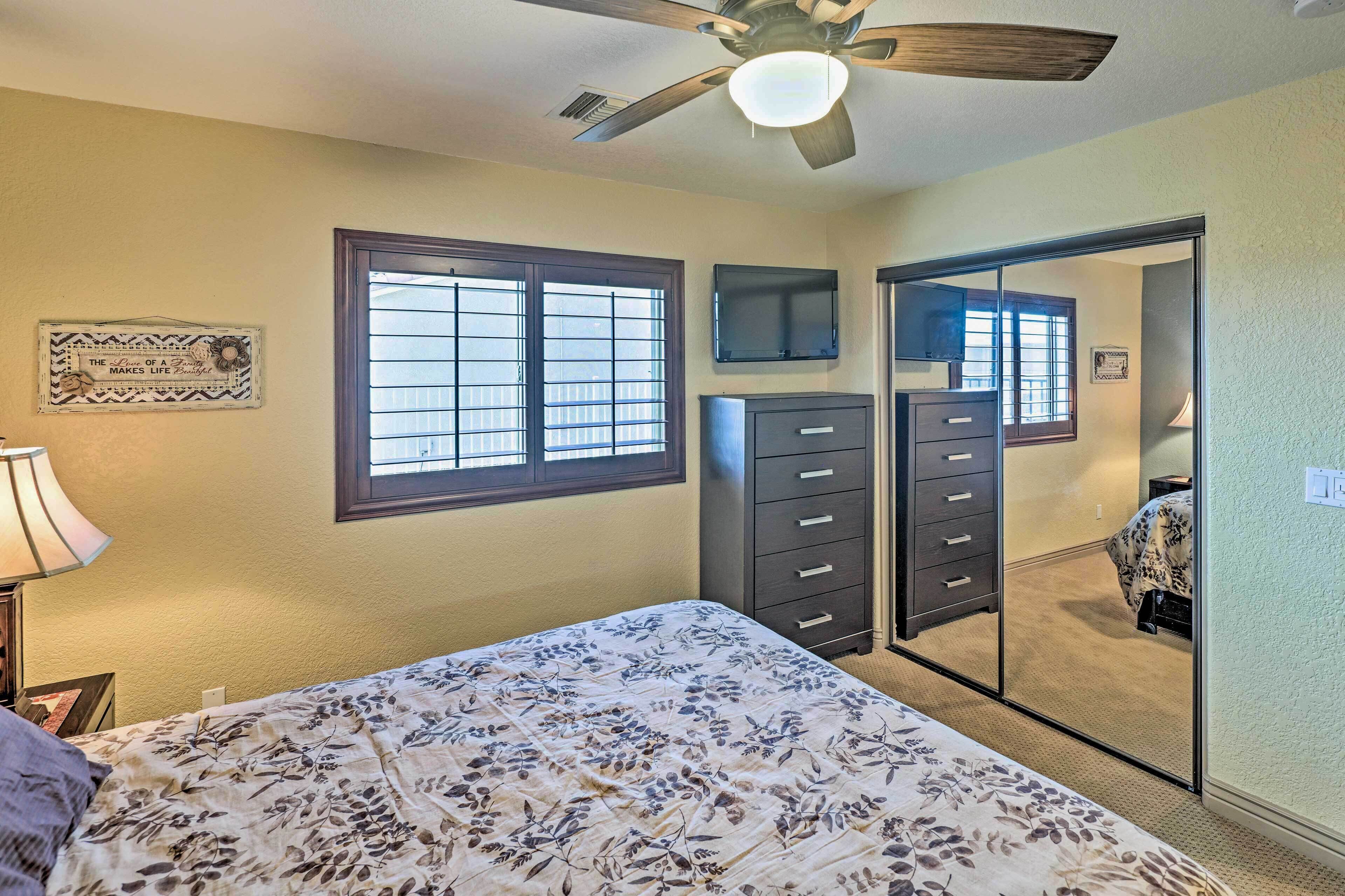 Une chambre à coucher avec un lit, une commode et un ventilateur de plafond.