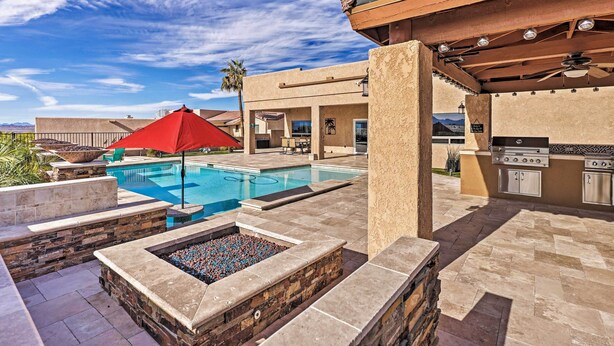 An outdoor pool area with a red umbrella, stone steps, and a grill. - Luxe Retreat w/ Lake Havasu View & Pool! (Lake Havasu City)