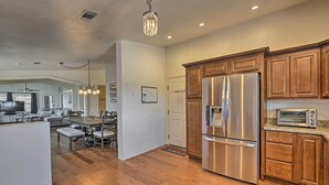 A modern kitchen with wooden cabinets, stainless steel appliances, and a dining area with a table and chairs. - Arizona Room, Gas Grill: Charming Payson Home! (Payson)