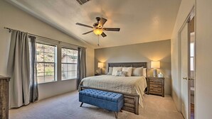 A bedroom with a large bed, a ceiling fan, a nightstand, and a bench. - Arizona Room, Gas Grill: Charming Payson Home! (Payson)