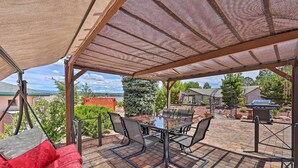 An outdoor patio with a covered seating area, a grill, and a view of the surrounding landscape. - Arizona Room, Gas Grill: Charming Payson Home! (Payson)