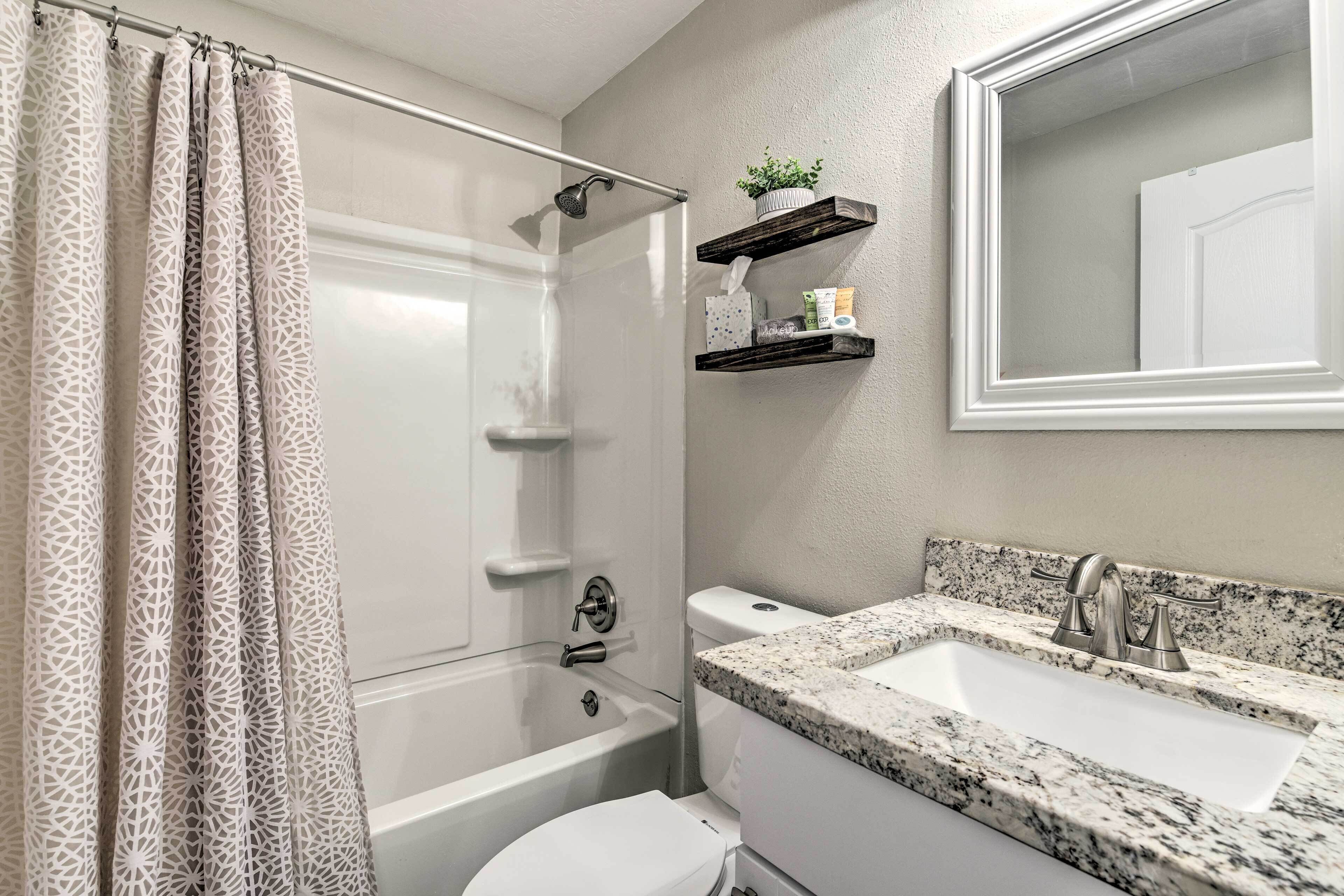 Une salle de bain équipée d’une douche, de toilettes, d’un lavabo et d’un miroir.