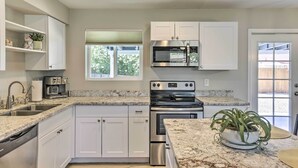 A modern kitchen with white cabinets, stainless steel appliances, and a granite countertop. - 3 Mi to Asu! Snowbird Poolside Escape in Tempe (Tempe)