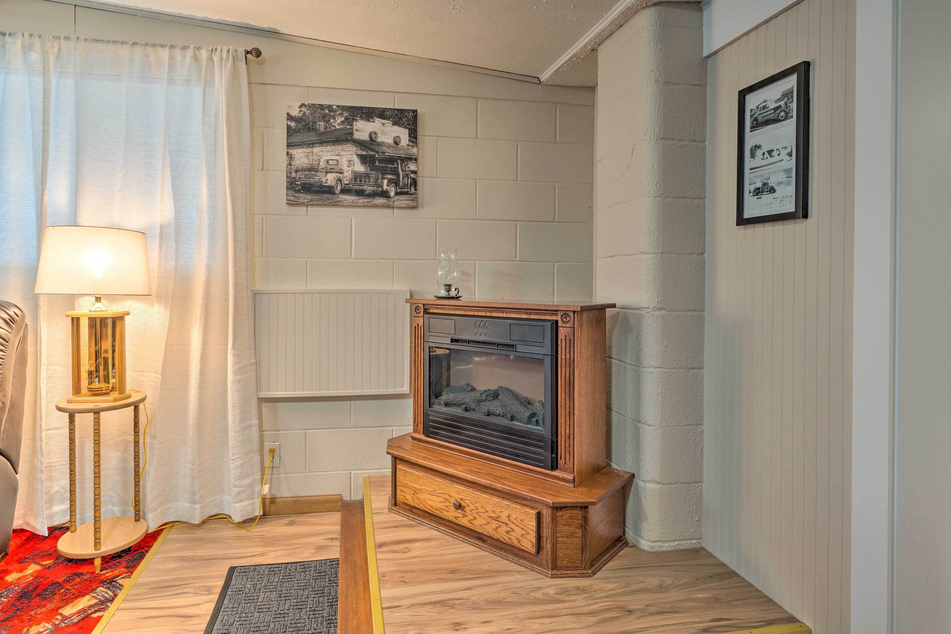Un salon avec un meuble TV en bois, une lampe, un radiateur et un tableau encadré accroché au mur.
