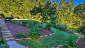 A landscaped garden with a stone staircase leading up, surrounded by various shrubs and a lawn. - Luxe Lake Chickamauga Retreat w/ Boat Dock! (Harrison)